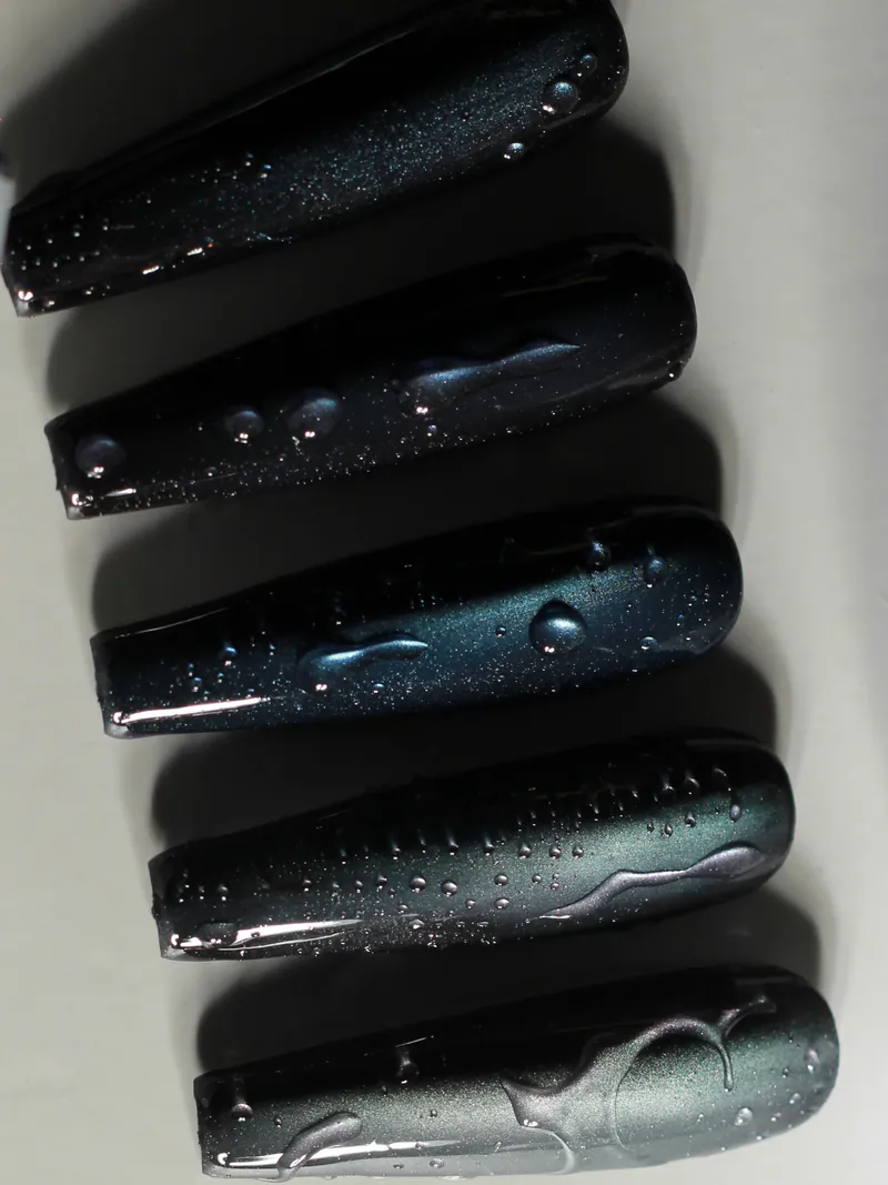 Long coffin sample tips in midnight blue cat-eye with raised clear droplets and trails.